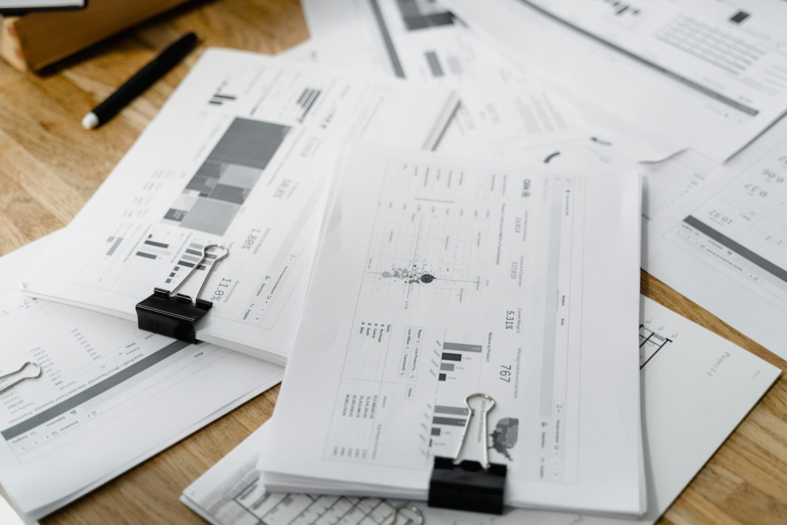 CPA-ready construction financial reports and job costing analytics Construction financial reports and performance charts spread across a desk for monthly job costing review